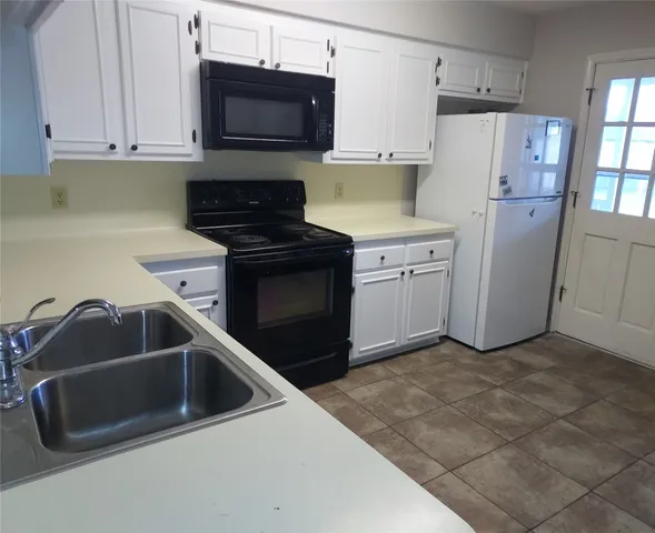a kitchen with refrigerator sink and cabinets