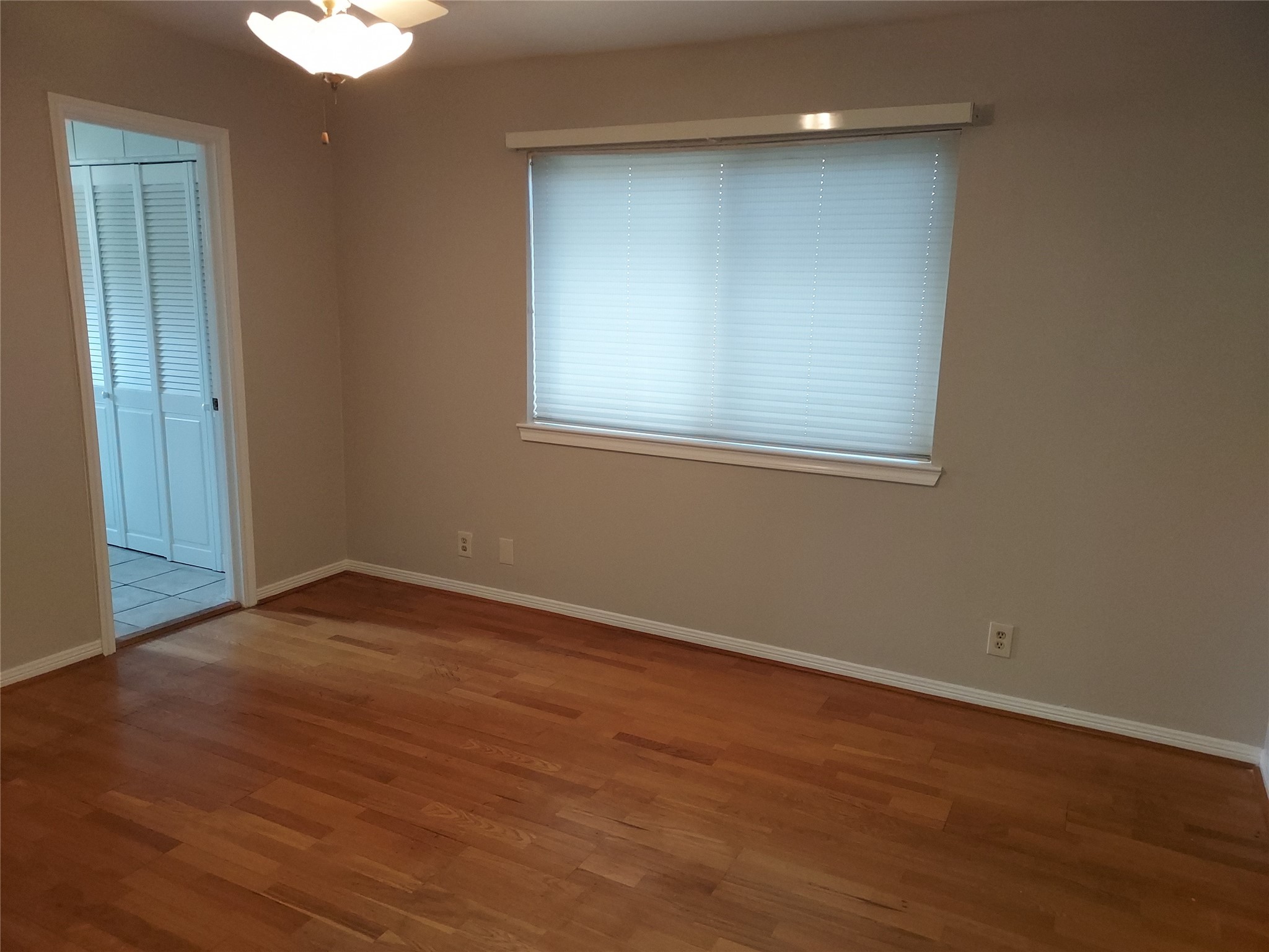 1305 Sagebrush Street Angleton, TX 77515 - Photo 5 of 12 a view of an empty room with wooden floor and a window
