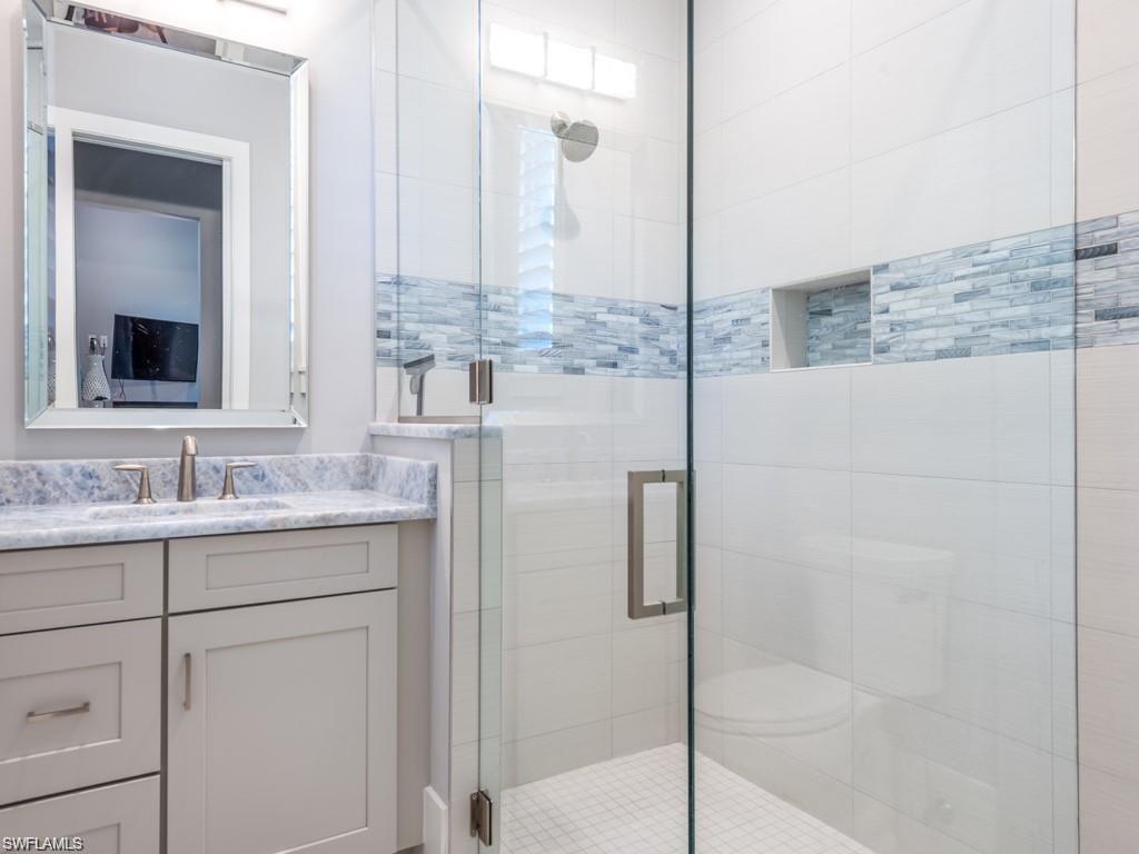 16892 Brightling Way Naples, FL 34110 - Photo 15 of 33 a bathroom with a granite countertop sink and a mirror