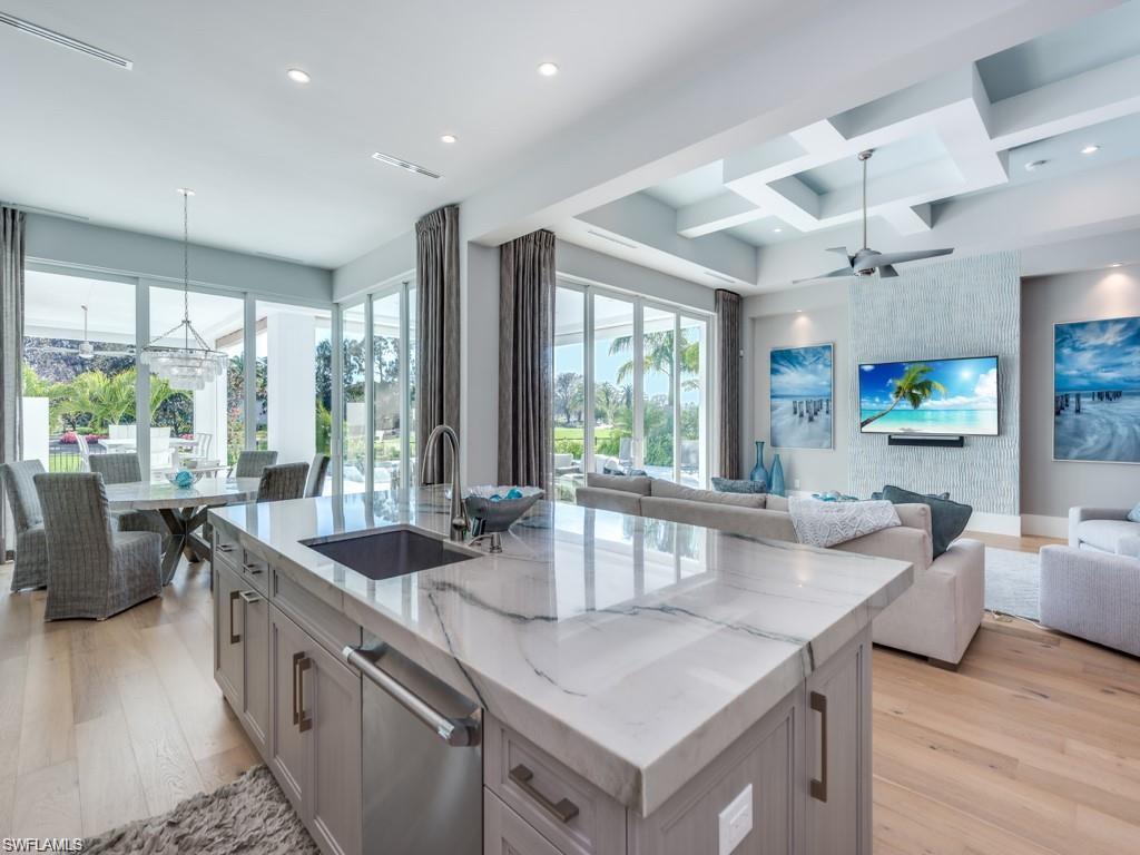 16892 Brightling Way Naples, FL 34110 - Photo 5 of 33 a kitchen with granite countertop a sink a counter top space and living room view