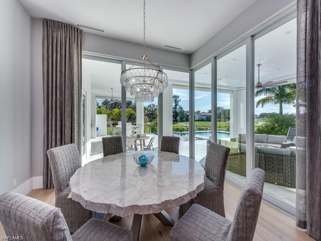 16892 Brightling Way Naples, FL 34110 - Photo 6 of 33 a view of a dining room with furniture large windows and wooden floor