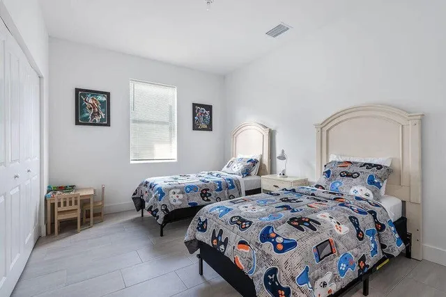 a bedroom with two beds and a window