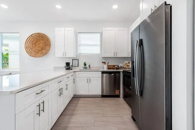 a kitchen with granite countertop a refrigerator stove top oven and sink