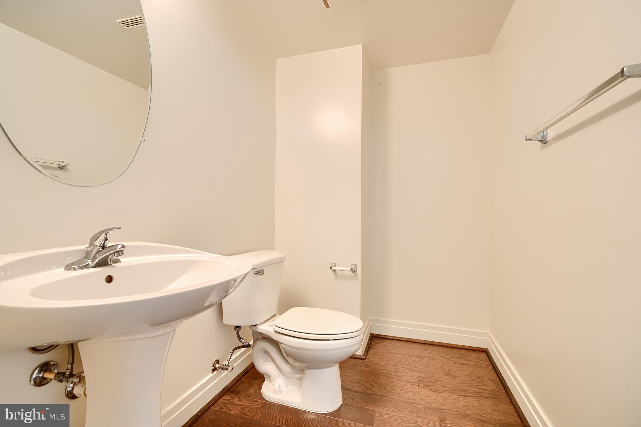 414 Water Street, Unit 1513 Baltimore, MD 21202 - Photo 17 of 43 a bathroom with a sink a toilet and a mirror