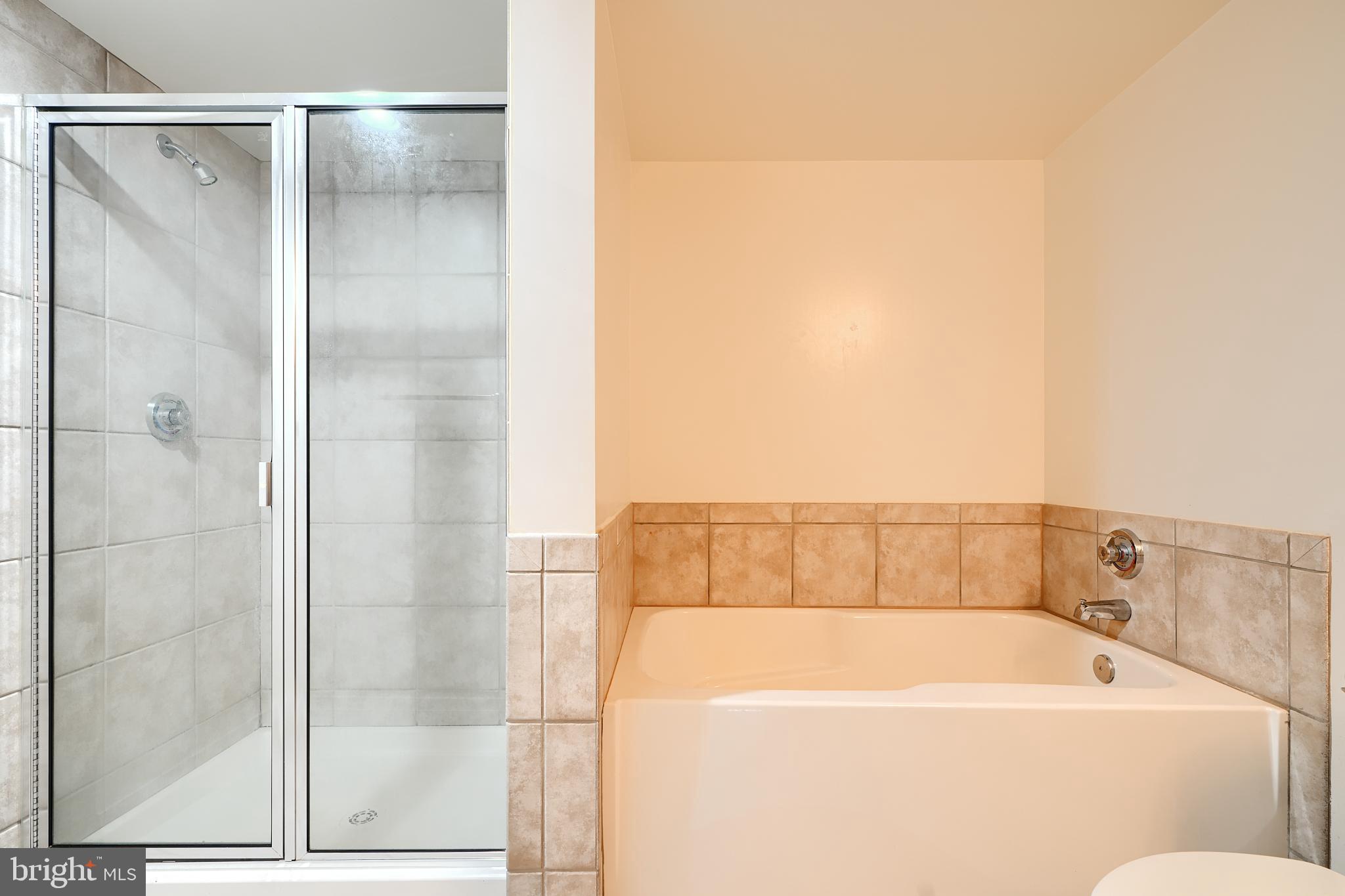 414 Water Street, Unit 1513 Baltimore, MD 21202 - Photo 25 of 43 a bathroom with a bathtub and a shower