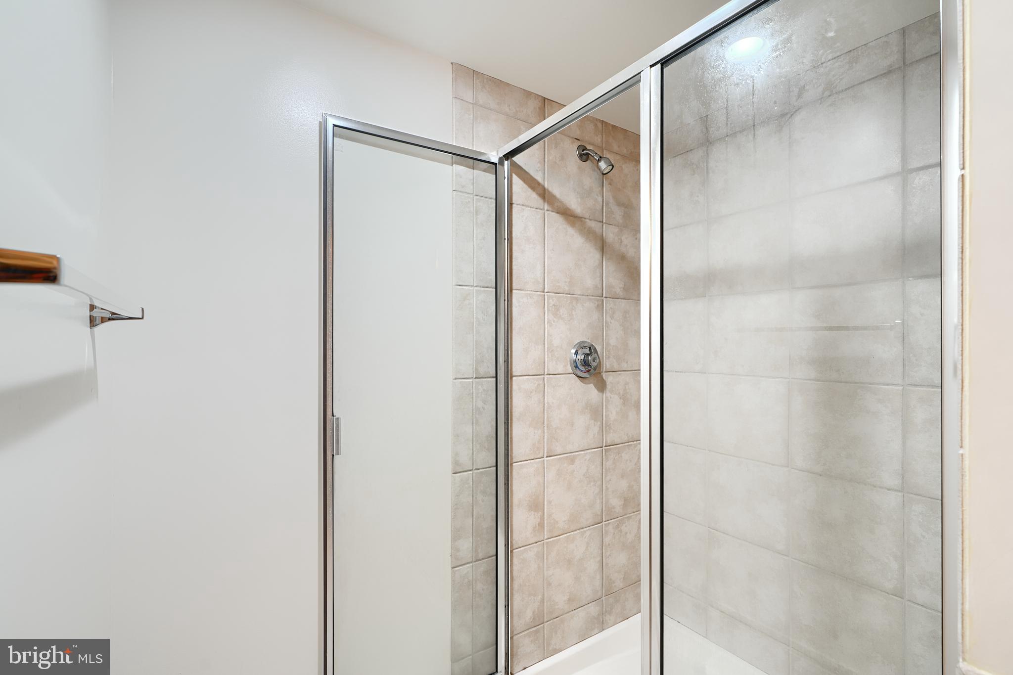 414 Water Street, Unit 1513 Baltimore, MD 21202 - Photo 27 of 43 a bathroom with a glass shower door