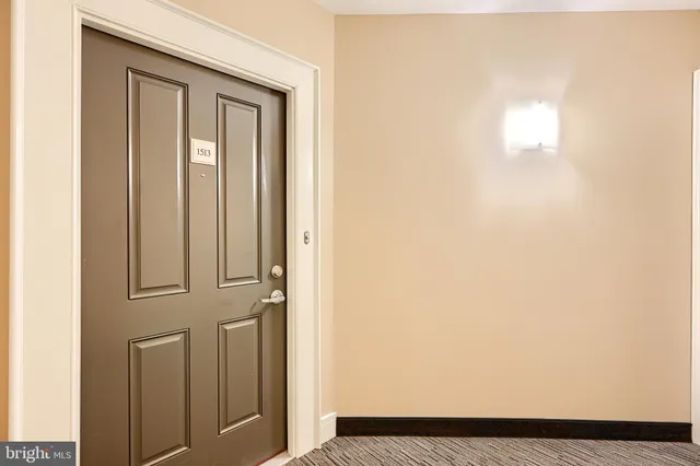 an empty room with wooden floor fireplace and windows