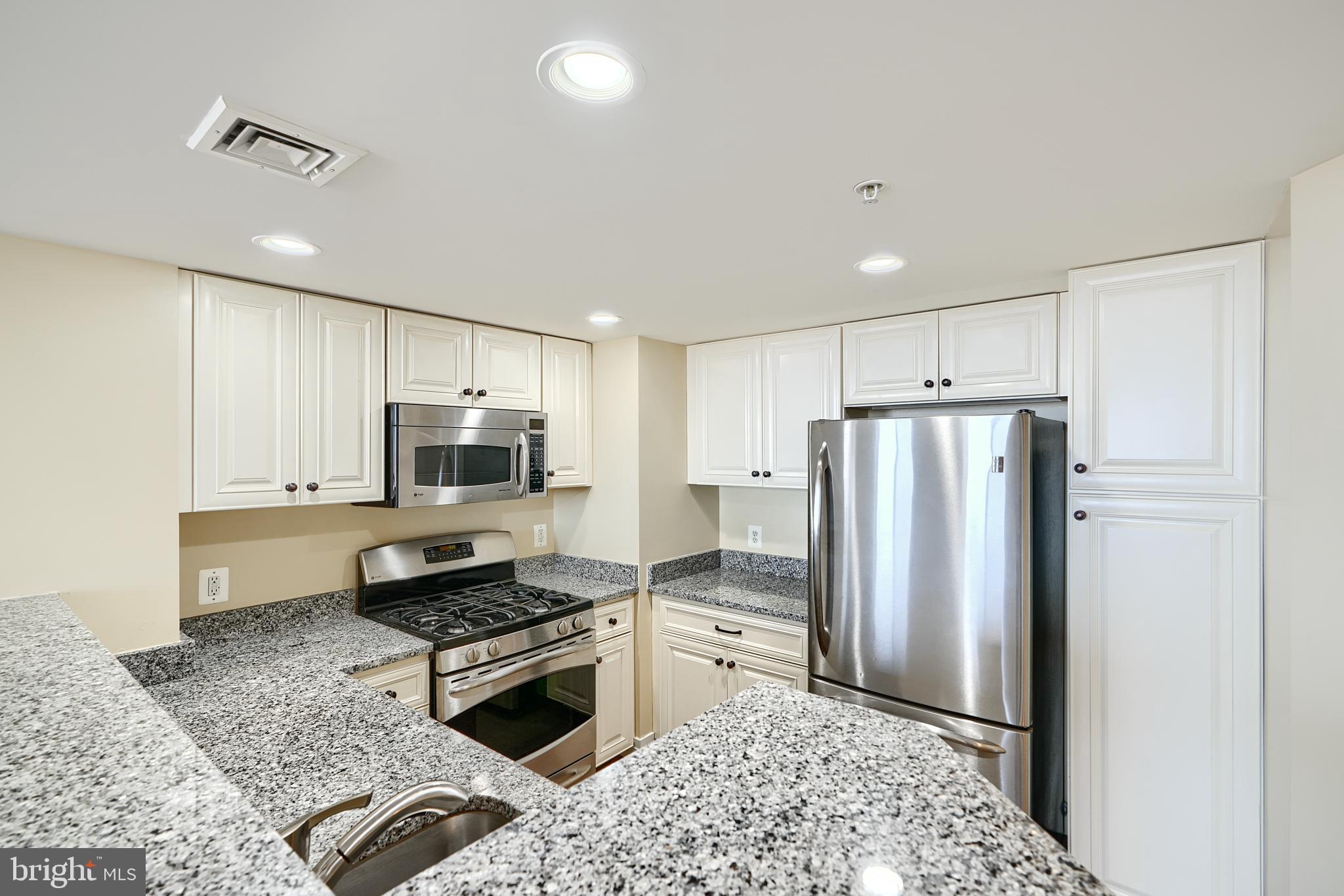 414 Water Street, Unit 1513 Baltimore, MD 21202 - Photo 10 of 43 a kitchen with stainless steel appliances a refrigerator sink and stove