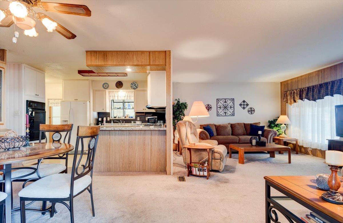 1272 Villa Avenue, Unit SPC56 Clovis, CA 93612 - Photo 4 of 35 a kitchen with stainless steel appliances kitchen island granite countertop a table and chairs in it