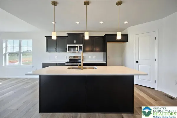 a kitchen with kitchen island a sink stainless steel appliances and window