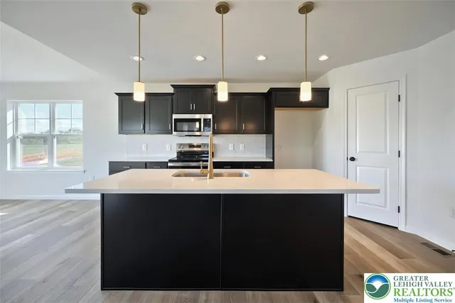 a kitchen with kitchen island a sink stainless steel appliances and window