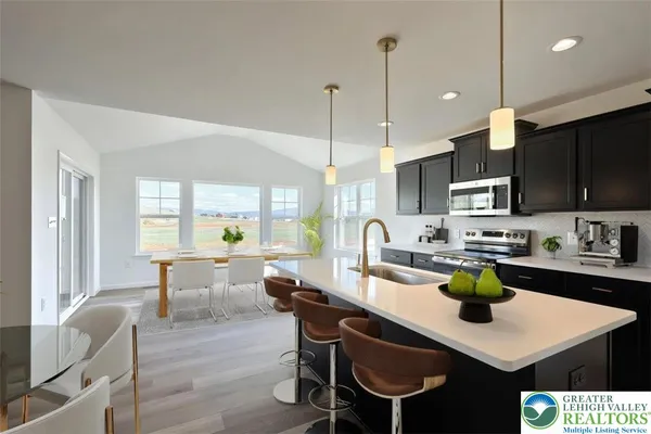a kitchen with a dining table chairs and view of living room