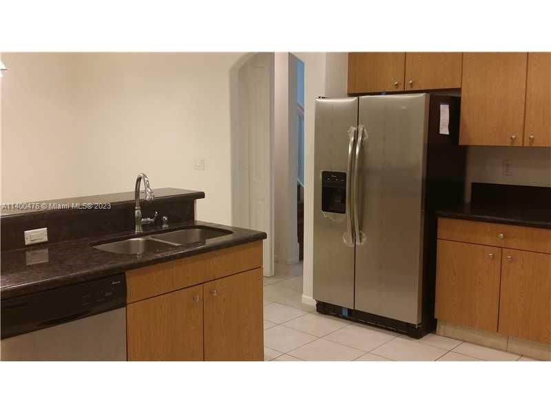 8436 Southwest 29th Street, Unit 101 Miramar, FL 33025 - Photo 5 of 21 a kitchen with a refrigerator and cabinets