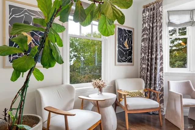 a dining room with furniture a potted plant and a large window