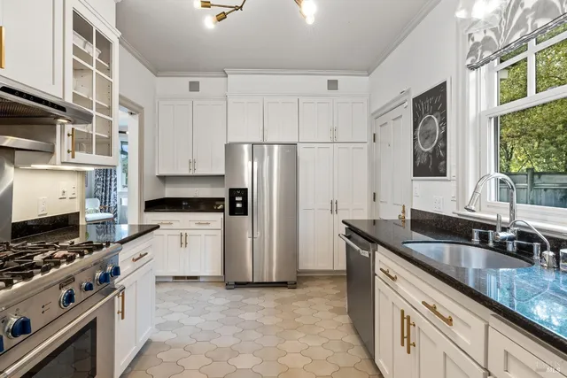 a kitchen with granite countertop a sink stove and refrigerator