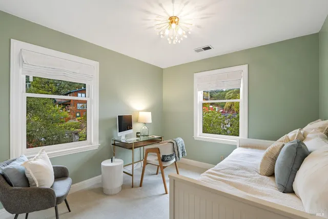 a bedroom with a bed a desk and a window