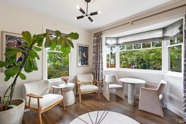 a living room with patio furniture and a potted plant