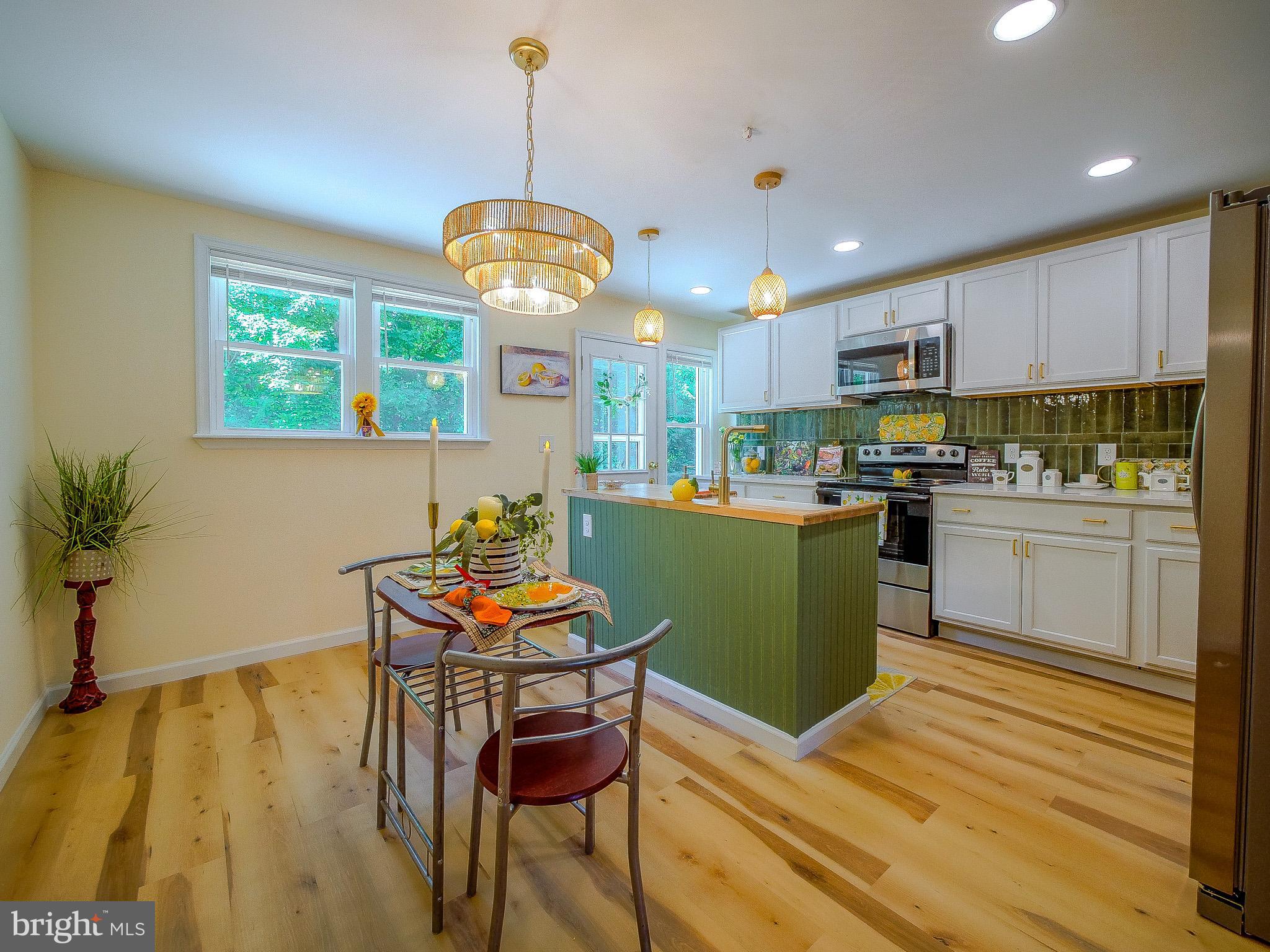 179 Madison Drive Newark, DE 19711 - Photo 14 of 43 a kitchen with kitchen island stainless steel appliances granite countertop a sink a stove a dining table chairs and view living room