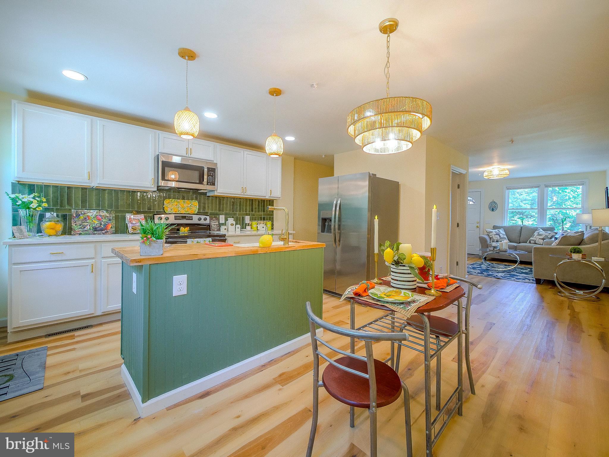 179 Madison Drive Newark, DE 19711 - Photo 19 of 43 a kitchen with stainless steel appliances granite countertop a stove top oven a sink dishwasher and white cabinets with wooden floor