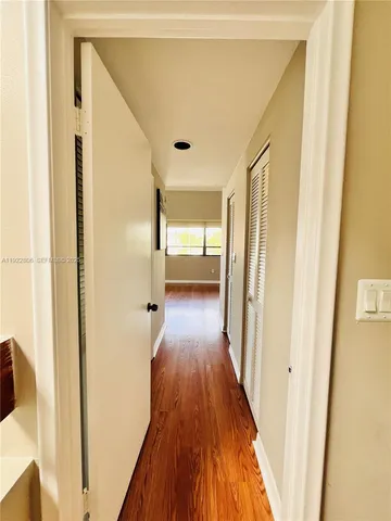 a view of a hallway with wooden floor and staircase