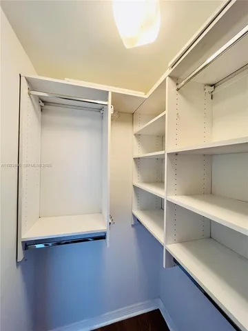 a view of walk in closet with empty racks