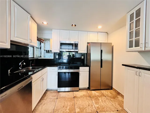 a kitchen with stainless steel appliances granite countertop a refrigerator sink and cabinets
