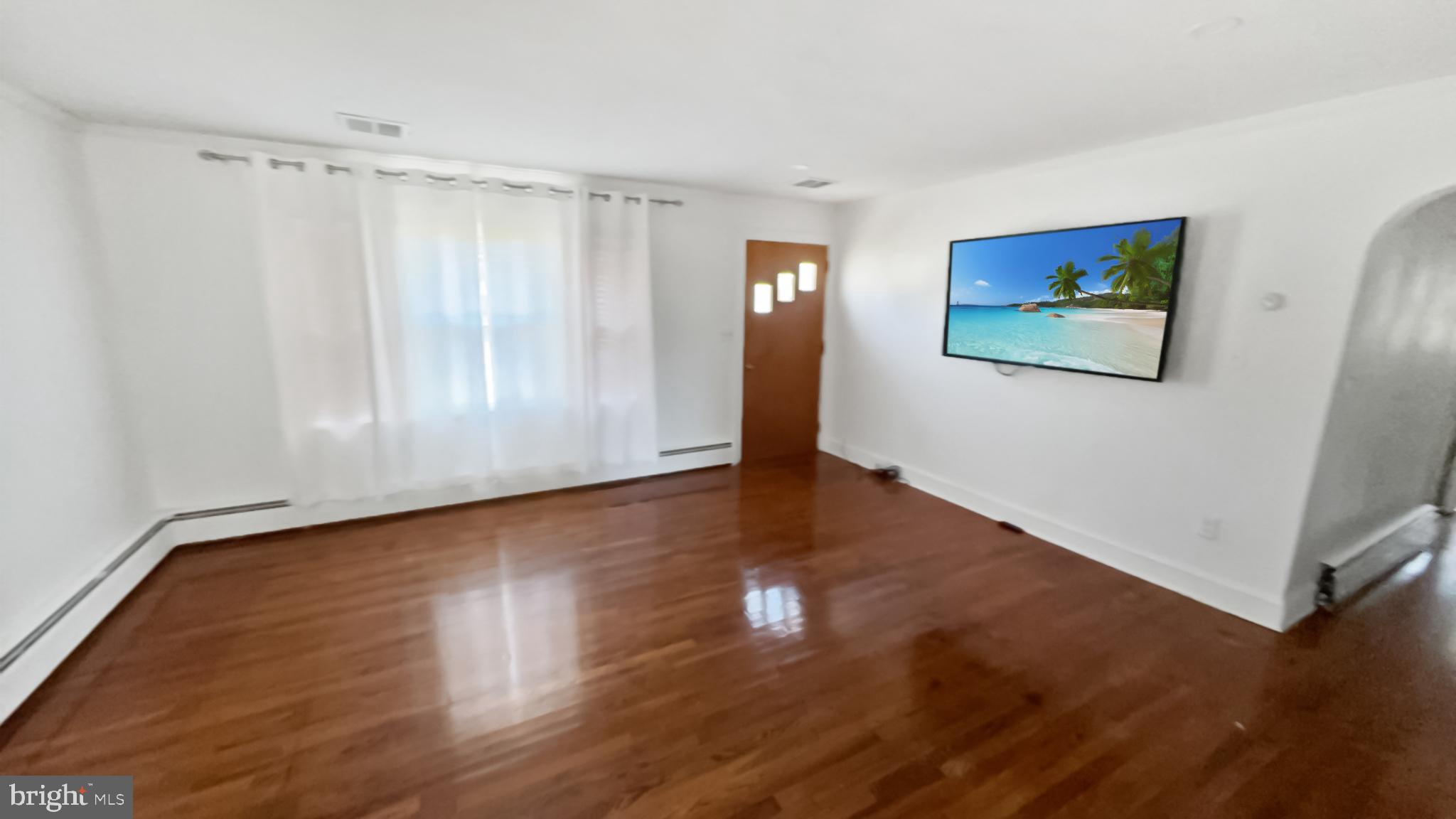 13 Nanticoke Road Cambridge, MD 21613 - Photo 3 of 14 a view of an empty room with wooden floor and a window