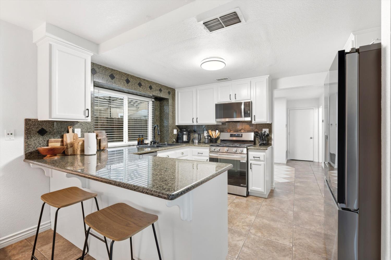 8117 Prior Way Antelope, CA 95843 - Photo 13 of 27 a kitchen with stainless steel appliances granite countertop a stove refrigerator sink and cabinets
