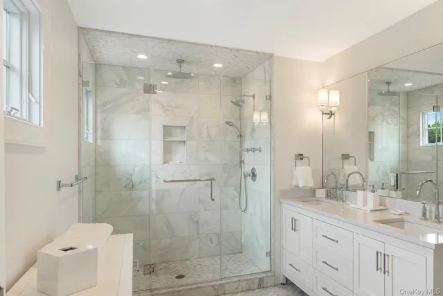a bathroom with a granite countertop shower sink mirror and toilet