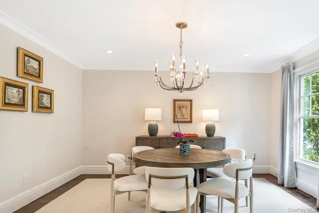 a view of a dining room with furniture a chandelier and window