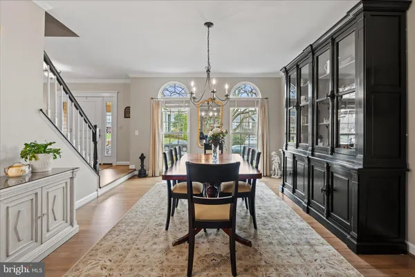 a kitchen with stainless steel appliances granite countertop a stove a sink dishwasher a microwave oven and a dining table with wooden floor