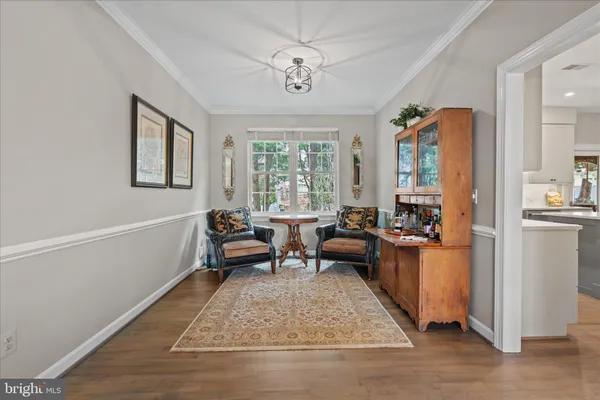 a kitchen with stainless steel appliances kitchen island granite countertop a table chairs and a refrigerator