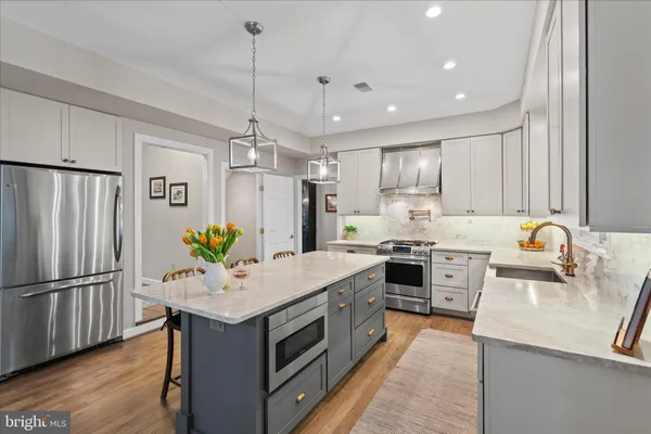 a large kitchen with kitchen island a large island in it