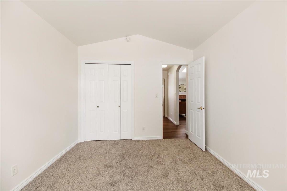2032 Talus Loop Twin Falls, ID 83301 - Photo 23 of 43 Interior room featuring vaulted ceilings, neutral carpeting, and light-toned walls