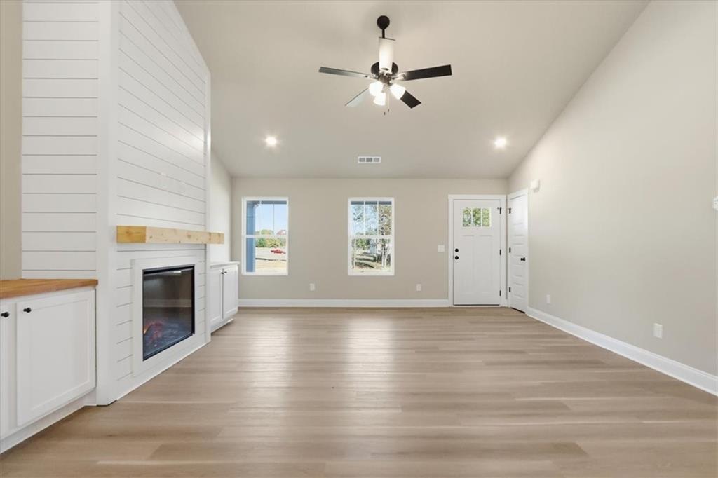 184 Rachel Lane Hartwell, GA 30643 - Photo 12 of 58 an empty room with windows fireplace and fans