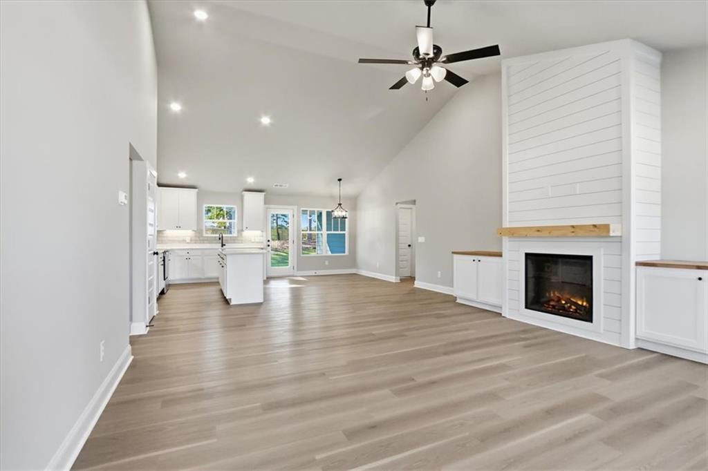 184 Rachel Lane Hartwell, GA 30643 - Photo 9 of 58 a view of an empty room with a fireplace a ceiling fan and kitchen view