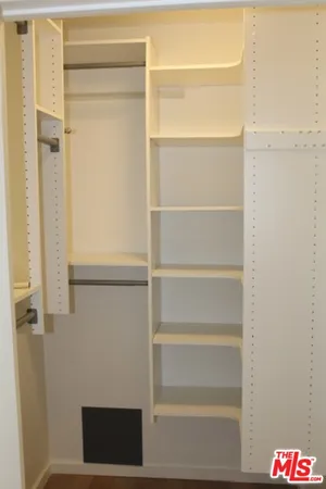 a view of walk in closet with empty racks