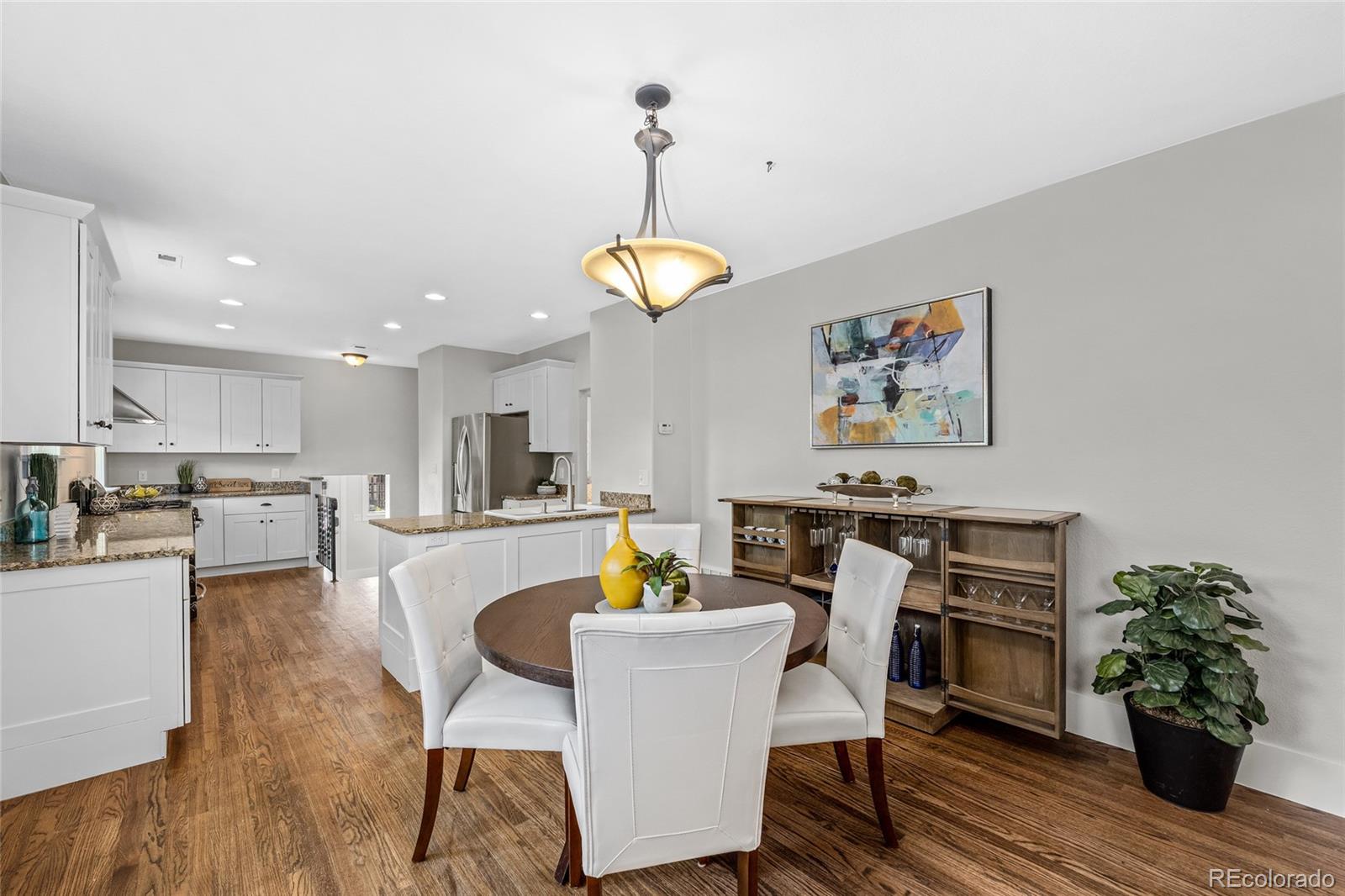 2829 Ash Street Denver, CO 80207 - Photo 11 of 40 a view of a dining room with furniture wooden floor and a chandelier