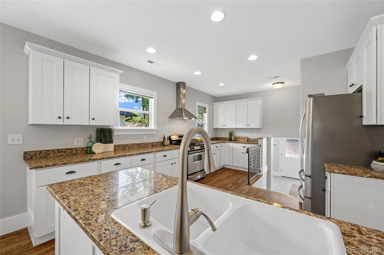 2829 Ash Street Denver, CO 80207 - Photo 17 of 40 a kitchen with stainless steel appliances granite countertop a sink refrigerator and cabinets