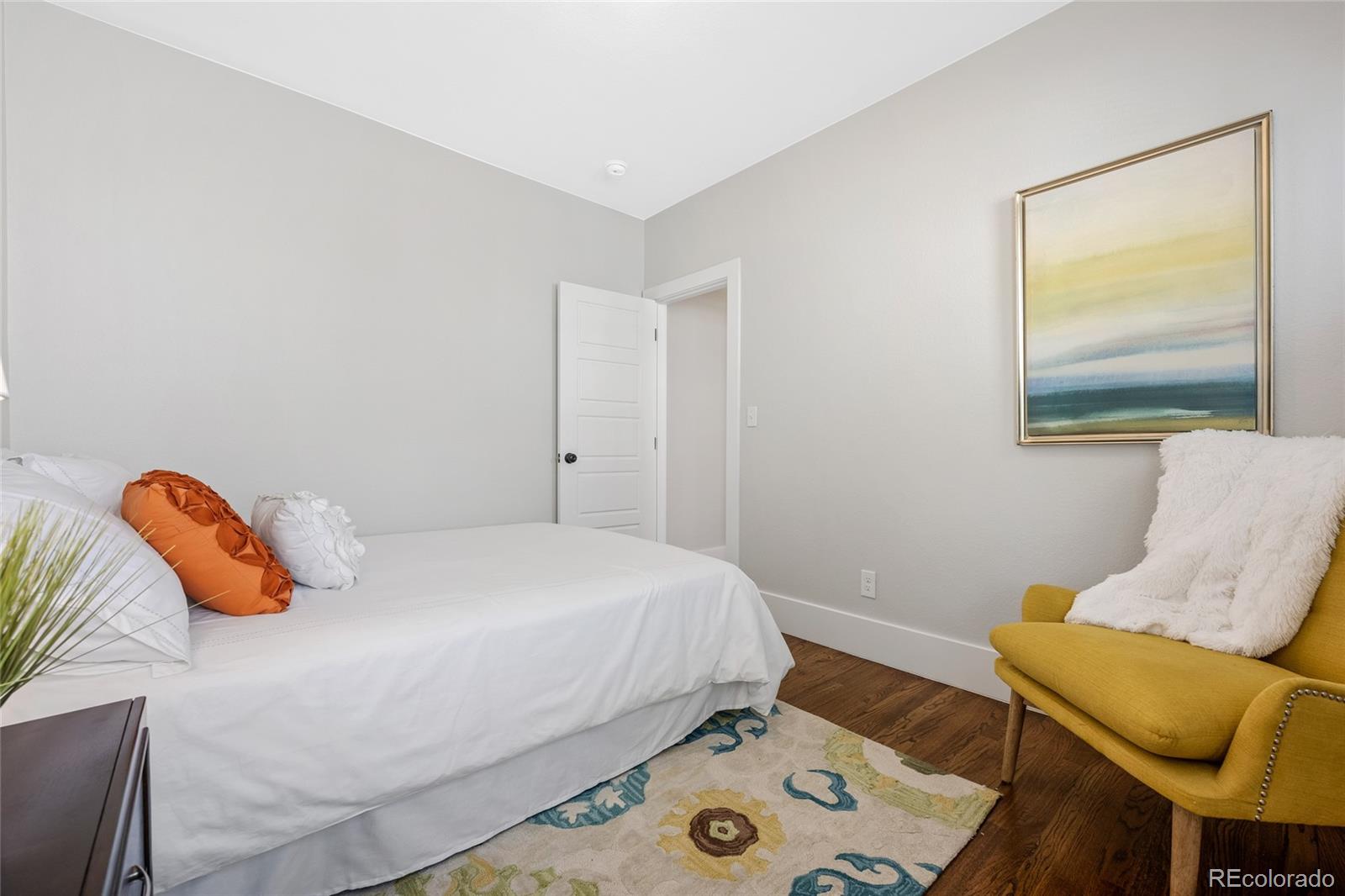 2829 Ash Street Denver, CO 80207 - Photo 21 of 40 a bedroom with a bed and chair
