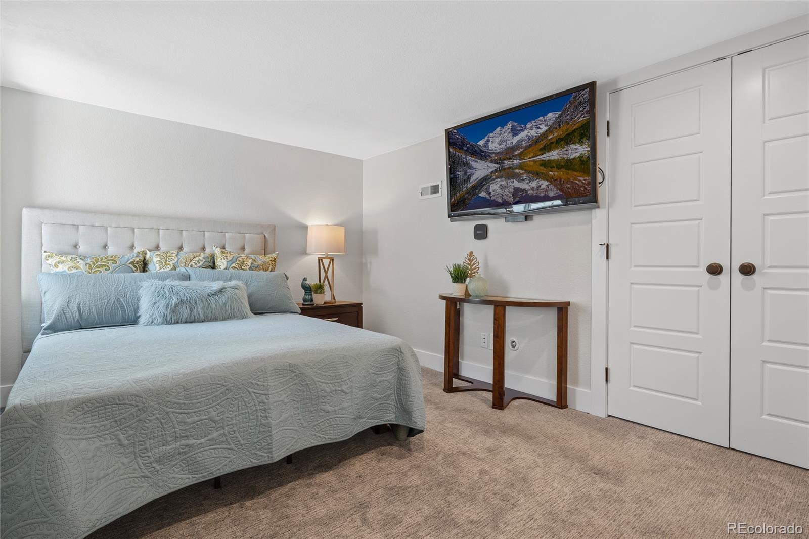 2829 Ash Street Denver, CO 80207 - Photo 30 of 40 a bedroom with a bed and a wall painting