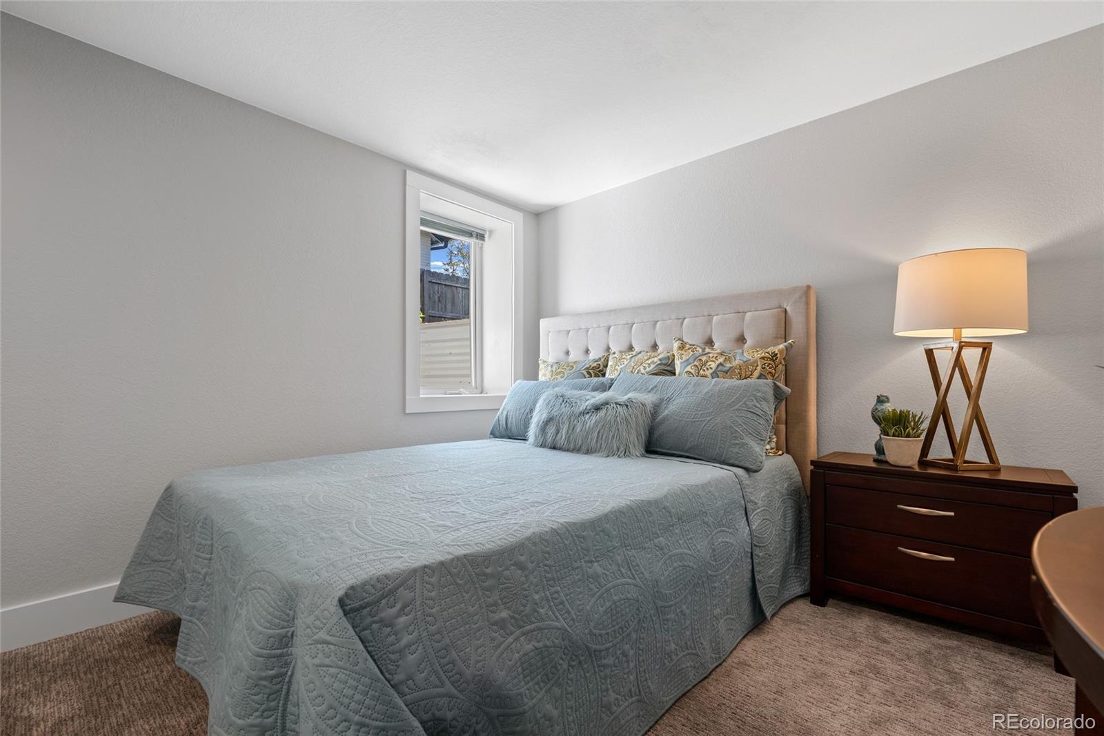 2829 Ash Street Denver, CO 80207 - Photo 31 of 40 a bedroom with a bed and a lamp