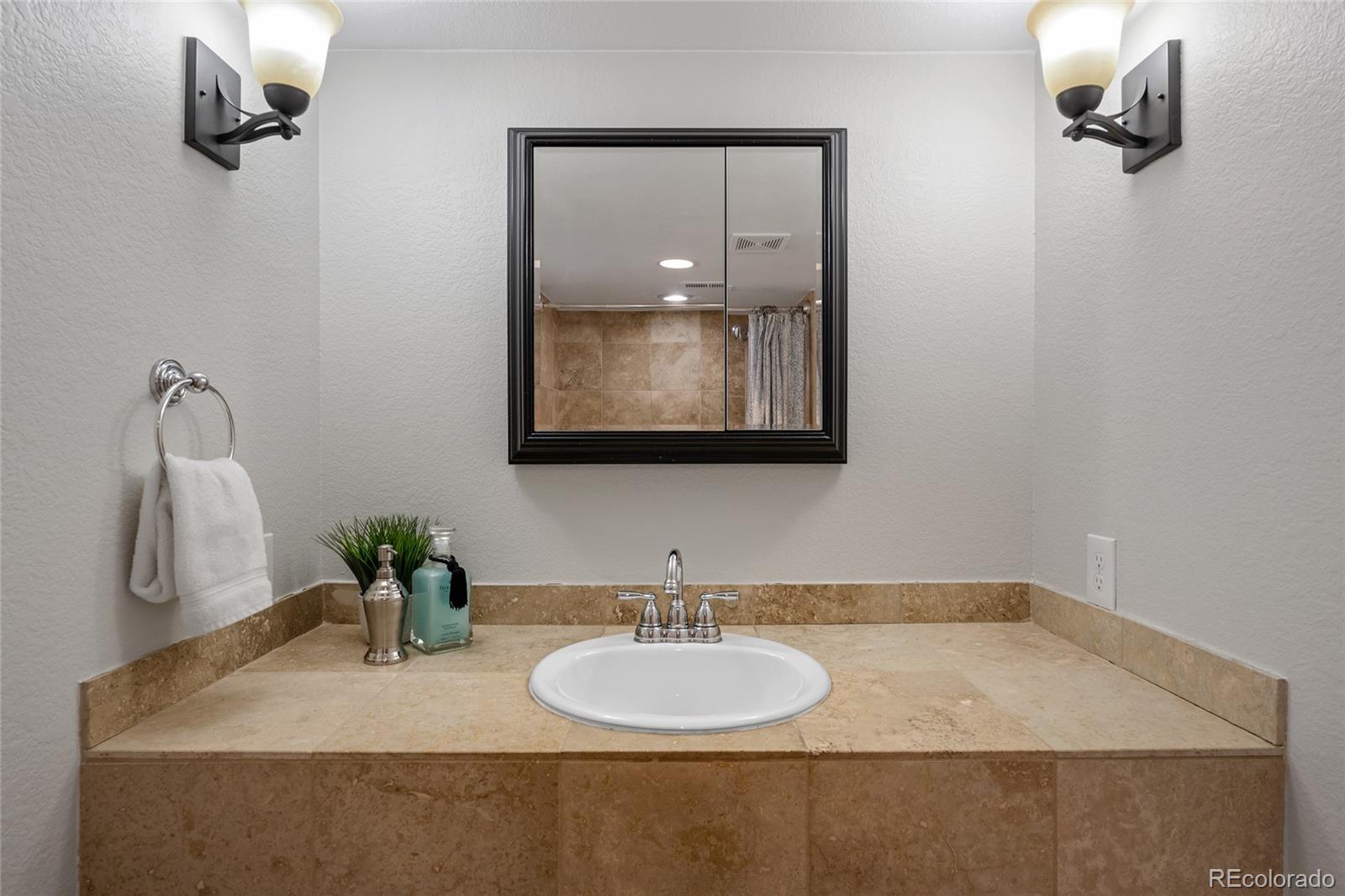 2829 Ash Street Denver, CO 80207 - Photo 32 of 40 a bathroom with a granite countertop sink and a mirror