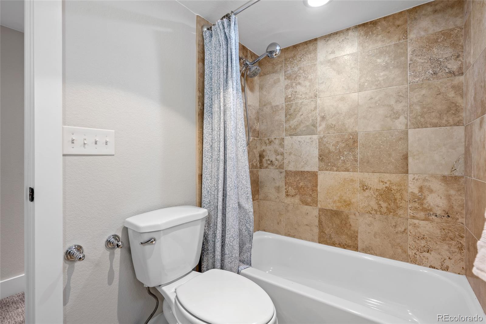 2829 Ash Street Denver, CO 80207 - Photo 33 of 40 a white toilet sitting next to a bath tub and a shower