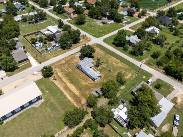 an aerial view of swimming pool a yard and plants