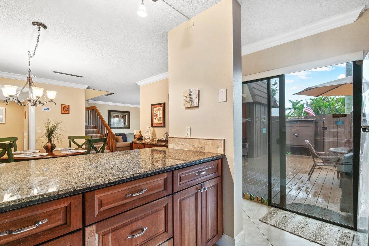 825 Center Street, Unit 13B Jupiter, FL 33458 - Photo 12 of 39 a kitchen with granite countertop a sink and a refrigerator