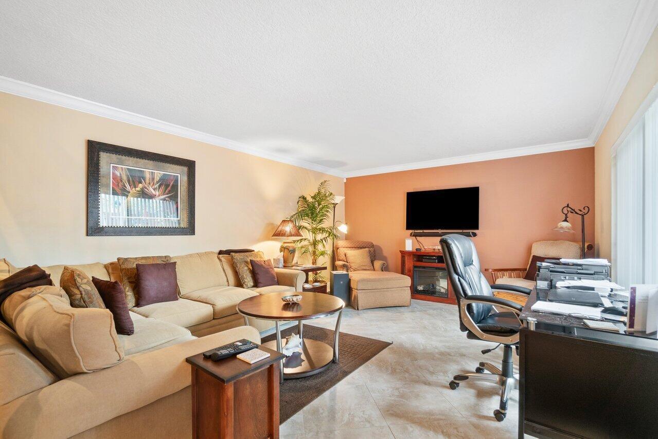 825 Center Street, Unit 13B Jupiter, FL 33458 - Photo 14 of 39 a living room with furniture a flat screen tv and a window