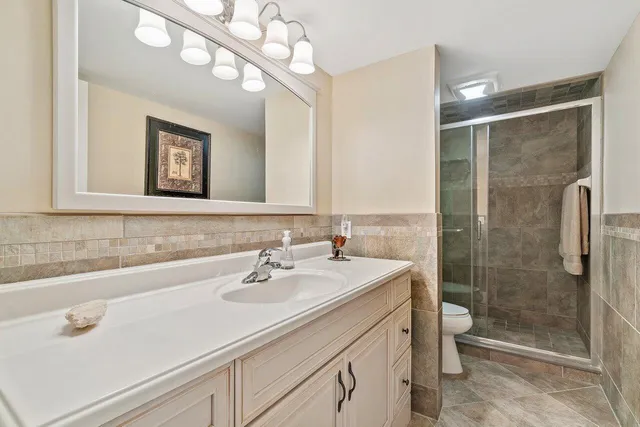 a bathroom with a sink a toilet and shower