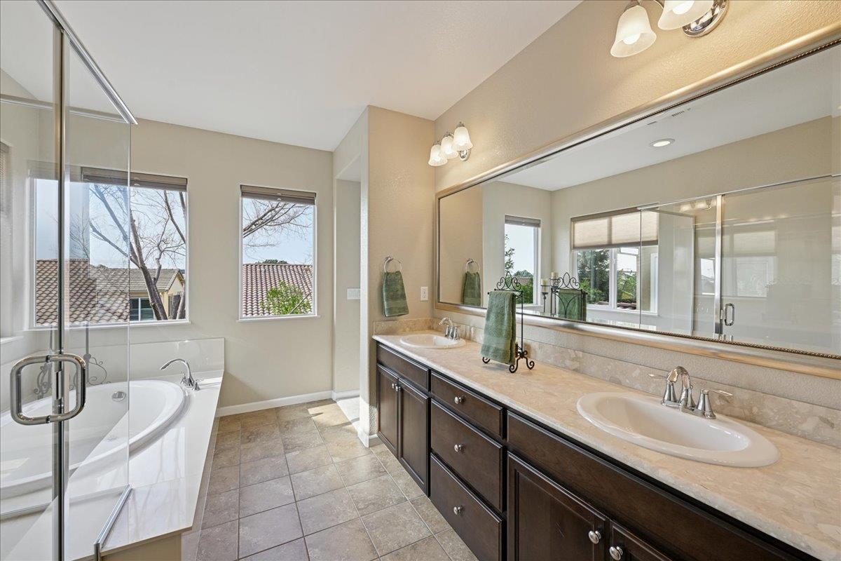 706 Wagon Trail Way Rocklin, CA 95765 - Photo 46 of 61 a bathroom with double vanity sinks a large mirror and a bathtub