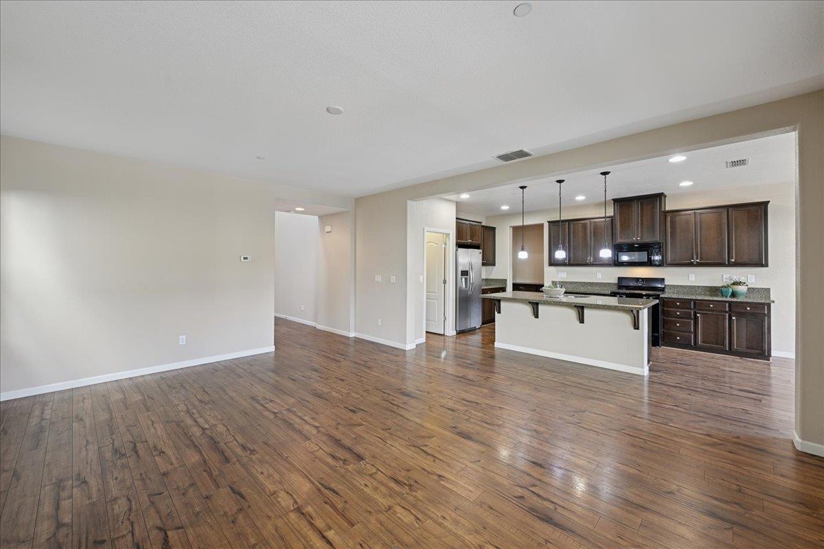 706 Wagon Trail Way Rocklin, CA 95765 - Photo 8 of 61 a kitchen with stainless steel appliances kitchen island wooden cabinets and granite counter tops